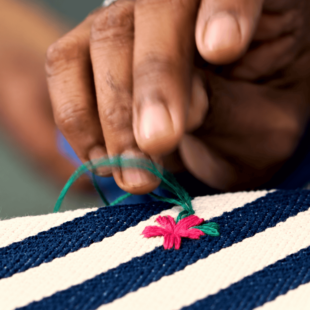 Close-up of skilled Chikankari artisan hands creating delicate handmade embroidery using traditional needle and thread techniques in Lucknow.